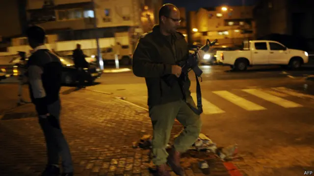 أفراد أمن إسرائيليون يتفقدون موقع سقوط صاروخ في مدينة سيدروت بصحراء النقب.