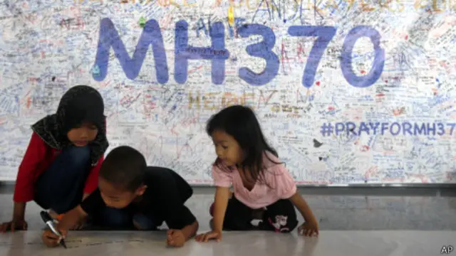 விமானத்தை கண்டு பிடிக்கக் கோரும் வாசகத்தில் சிறார்கள் கையெழுத்திடுகிறார்கள்