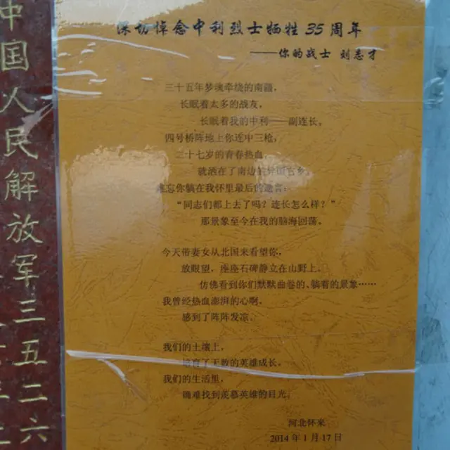 屏边县烈士陵园苟中利烈士墓碑旁贴着的一张打印塑封的诗。 