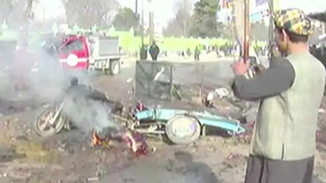 أفغاني يصور سيارة مفخخة عقب انفجارها في أحد الشوارع