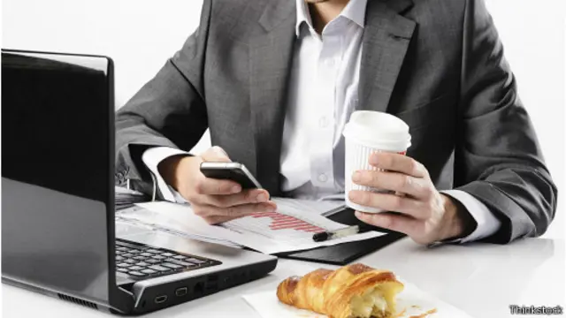 Hombre comiendo mientras trabaja