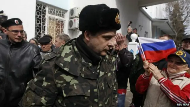 一名乌克兰海军军官在俄罗斯支持者的掌声中离开了塞瓦斯托波尔海军基地。