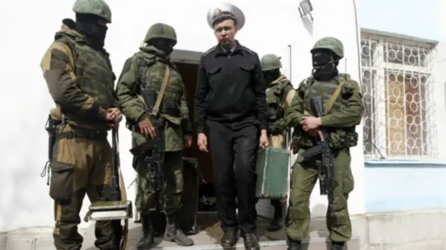 ایک یوکرائنی بحری فوج کا اہلکار اپنے سامان کے ساتھ بحریہ کے اڈے سے جا رہا ہے