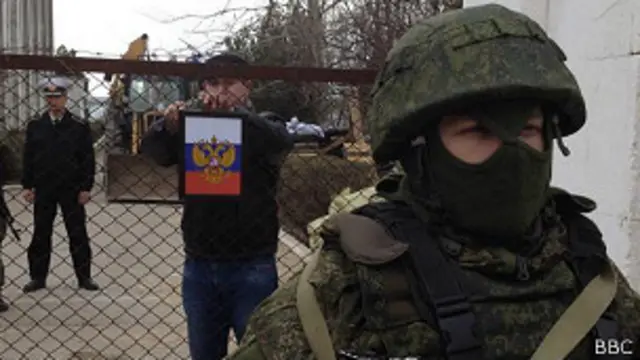 Российский "штандарт" на воротах украинской базы в Новоозерном, солдат без опознавательных знаков - перед воротами