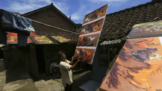 Pelukis mengeringkan lukisan 