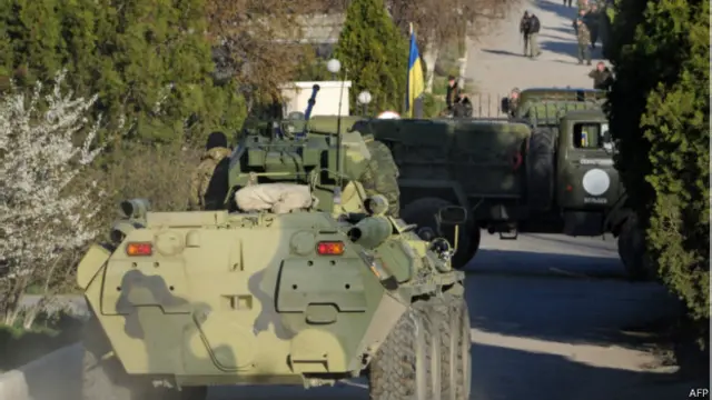 Dua kendaraan lapis baja menggempur tembok pangkalan angkatan udara Ukraina.