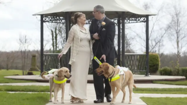 Sepasang kekasih menikah diiringi anjing penuntun mereka.