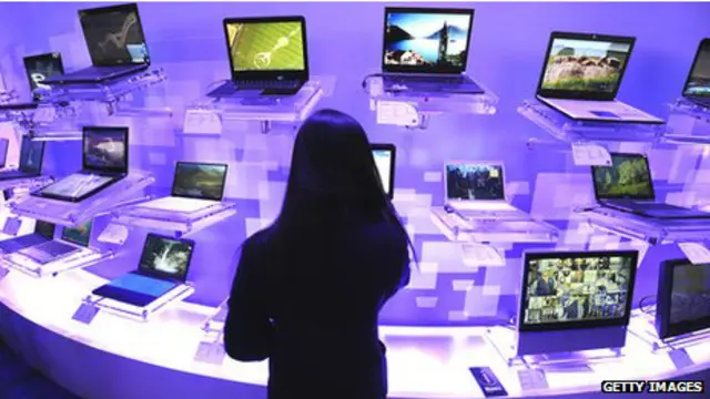Una mujer mirando laptops en una mesa