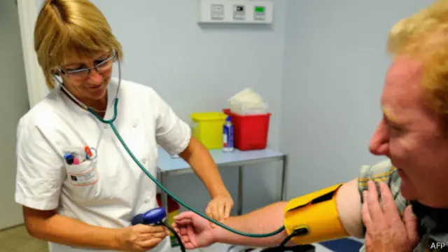 ممرضة تقيس ضغط الدم لمريض في مستشفي في فرنسا في سبتمبر/ أيلول 2013