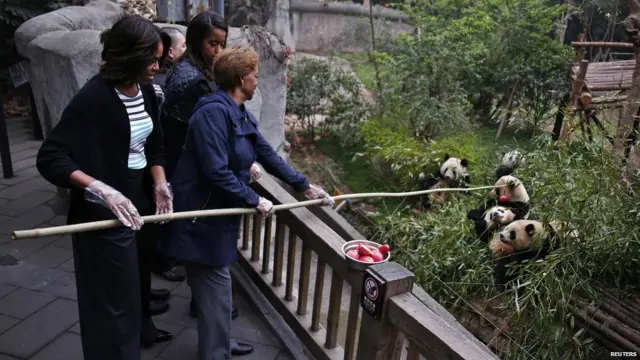 米歇尔（左）与母亲鲁滨逊夫人（右）用竹竿喂饲大熊猫（26/3/2014）