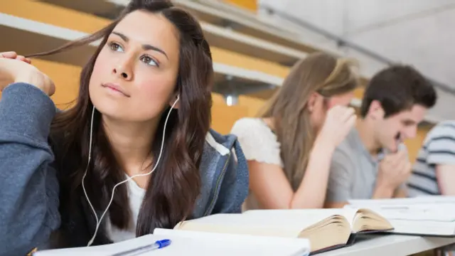 Joven estudiando con auriculares