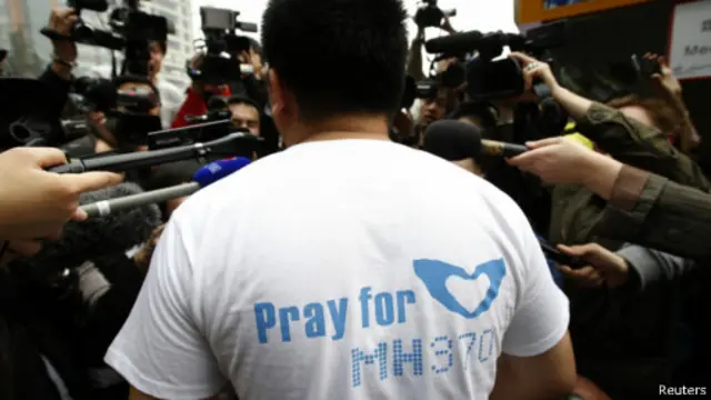 Steven Wang, familiar de um dos passageiros do voo MH370 é cercado pela imprensa em frente ao hotel Lido, em Pequim (Reuters)