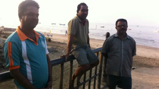 महाराष्ट्र के कोंकण इलाक़े में अलीबाग़ के समुद्र तट पर कुछ लोग.