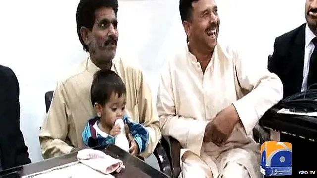 穆罕默德•摩薩•汗在法庭上坐在他爸爸的腿上受審。