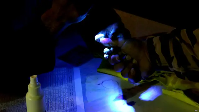 کارمندان کمیسیون انتخابات قبل از سپردن برگه رای دهی به رای دهندگان، انگشت‌ها مراجعه کننده‌ها را بررسی می‌کنند که جلو دوبار رای دهی افراد را بگیرند.