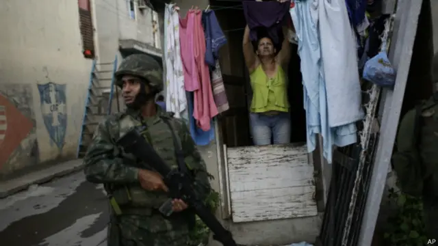 soldado em frente à casa de uma moradora da Maré | AP