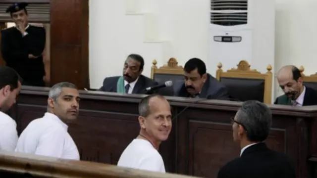 صحفيو الجزيرة الثلاثة يبتسمون اثناء وجودهم في قاعة المحكمة