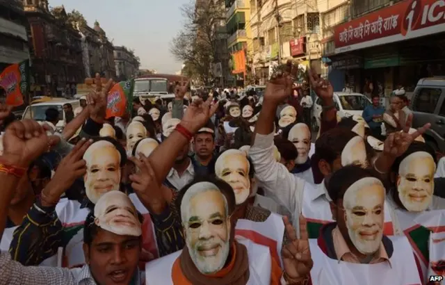 هواداران نارندرا مودی در حالی که ماسک‌هایی با چهره او بر صورت دارند، در یک میتینگ عمومی شرکت می‌کنند