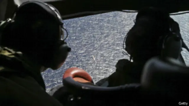 طيارين ينظرون خارج قمرة القيادة نحو المحيط الهندي ضمن عملية البحث عن الطائرة الماليزية المفقودة