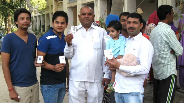 गुड़गांव में मतदाता पहचान पत्र दिखाते लोग.