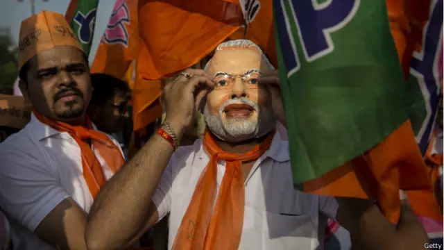 नरेंद्र मोदी का मुखौटा लगाए समर्थक