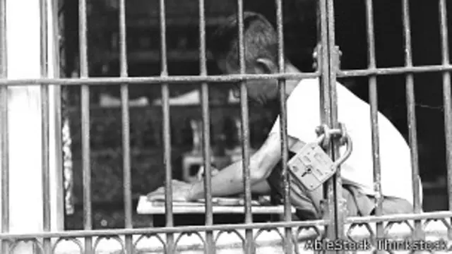 Persona escribiendo tras las rejas