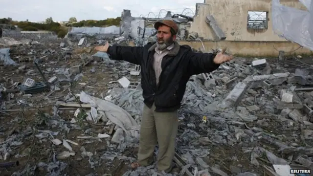 رجل يقف وسط حطام منزل