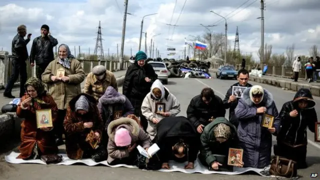 Warga Ukraina berdoa di depan aksi kelompok miliran pro Rusia di timur negara itu.