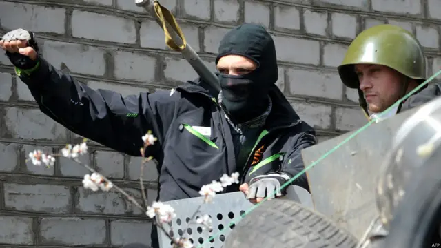 Молодые люди в масках и касках в центре Славянска.