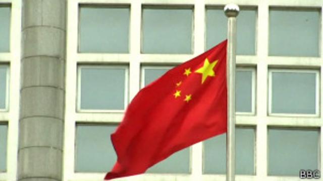 Китайский флаг перед зданием в Пекине