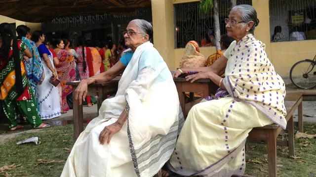 कूच बिहार के एक मतदान केंद्र पर अपनी बारी का इंतजार करती महिलाएं