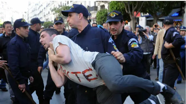 رجلا شرطة يقبضان على متظاهر في الجزائر