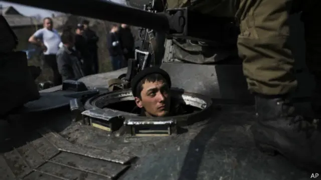 Soldado ucraniano em tanque crecado por militantes pró-Rússia