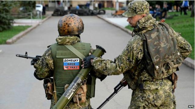 مسلح في مدينة سلوفيانسك شرق أوكرانيا يضع على ظهره ملصقا يقول "(مدينة) دونيتسك لا تستمع إلى كييف".