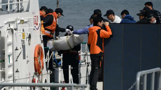 搜救人员将遇难者遗体运上岸