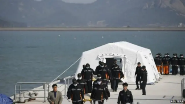 韩国海警将遇难者遗体运到码头的帐篷中