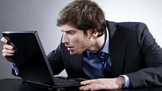 Una persona que mira su computadora con preocupación