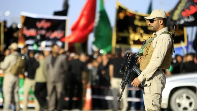 جندي يقف أمام تجمع انتخابي حاملا السلاح