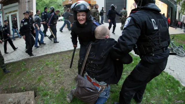 Міліціонери піднімають одного з постраждалих