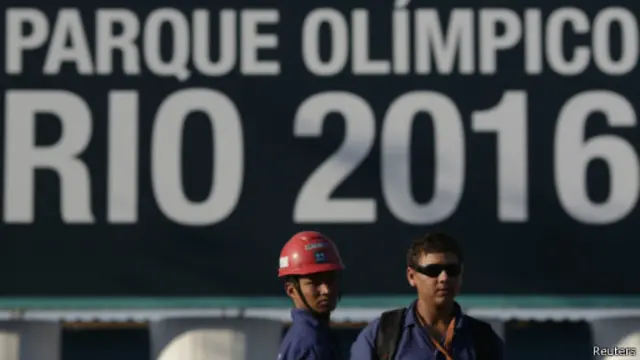 Строители в Рио на фоне олимпийского плаката