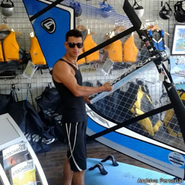 Jorge Armando Martínez con una tabla de windsurf en EE.UU.