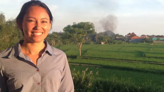 安德烈亞站在辦公室的陽台上，身後是碧綠的稻田