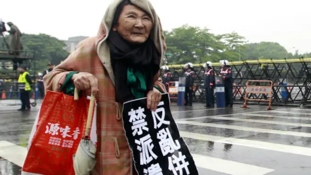 وفي تايبيه في تايوان وقفت عجوز أمام قصر الرئاسة محتجة.