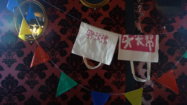 墙上还挂起了带有中文字的环保袋，以及来自各国游客的创意作品。