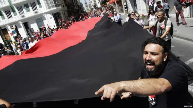 İspanya'daki gösterilerde işçiler kocaman bir bayrak taşıdı.