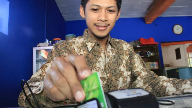 Dalam menyediakan layanannya, Agus dibekali mesin gesek kartu EDC.