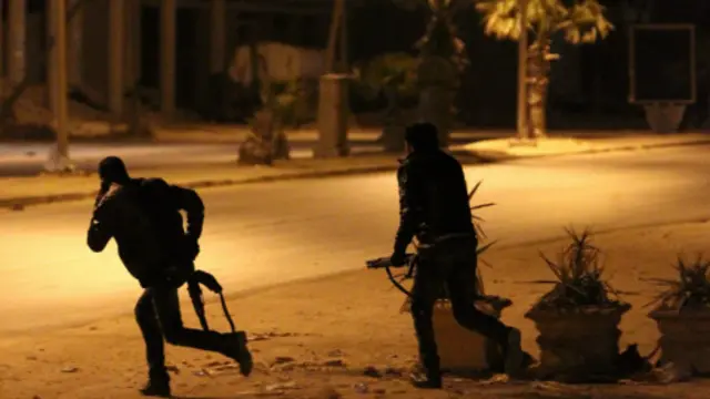 اثنان من قوات الامن الليبية يتقدمان صوب مقر قيادة الامن في بنغازي