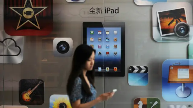 Cliente passe em frente a uma loja da Apple na China (Foto: AFP)