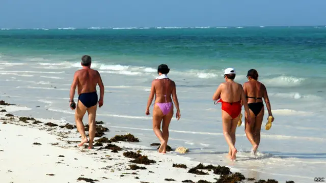 Turistas em praia de Zanzibar, na Tanzânia | Crédito: BBC