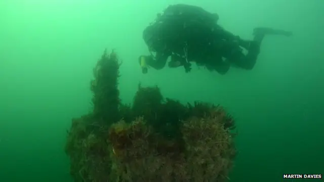 Para turis dapat melihat dari dekat menara komando bangkai kapal selam itu.